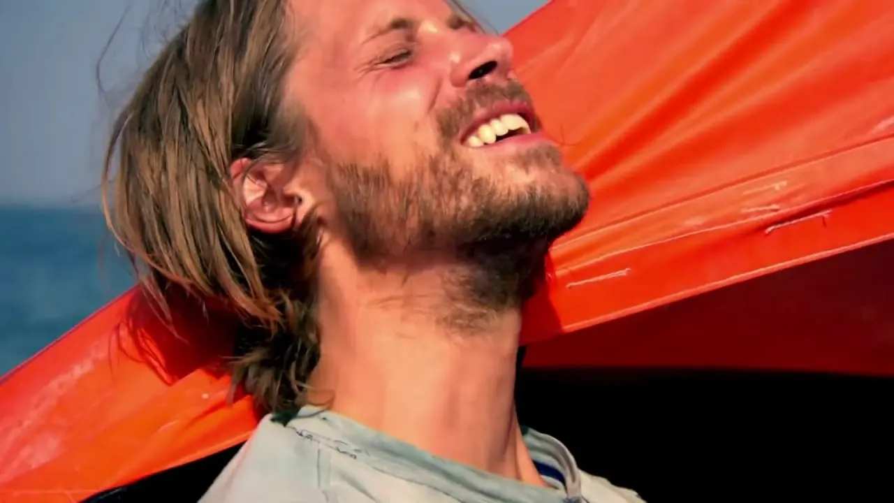 side profile of a bearded man with long hair at sea