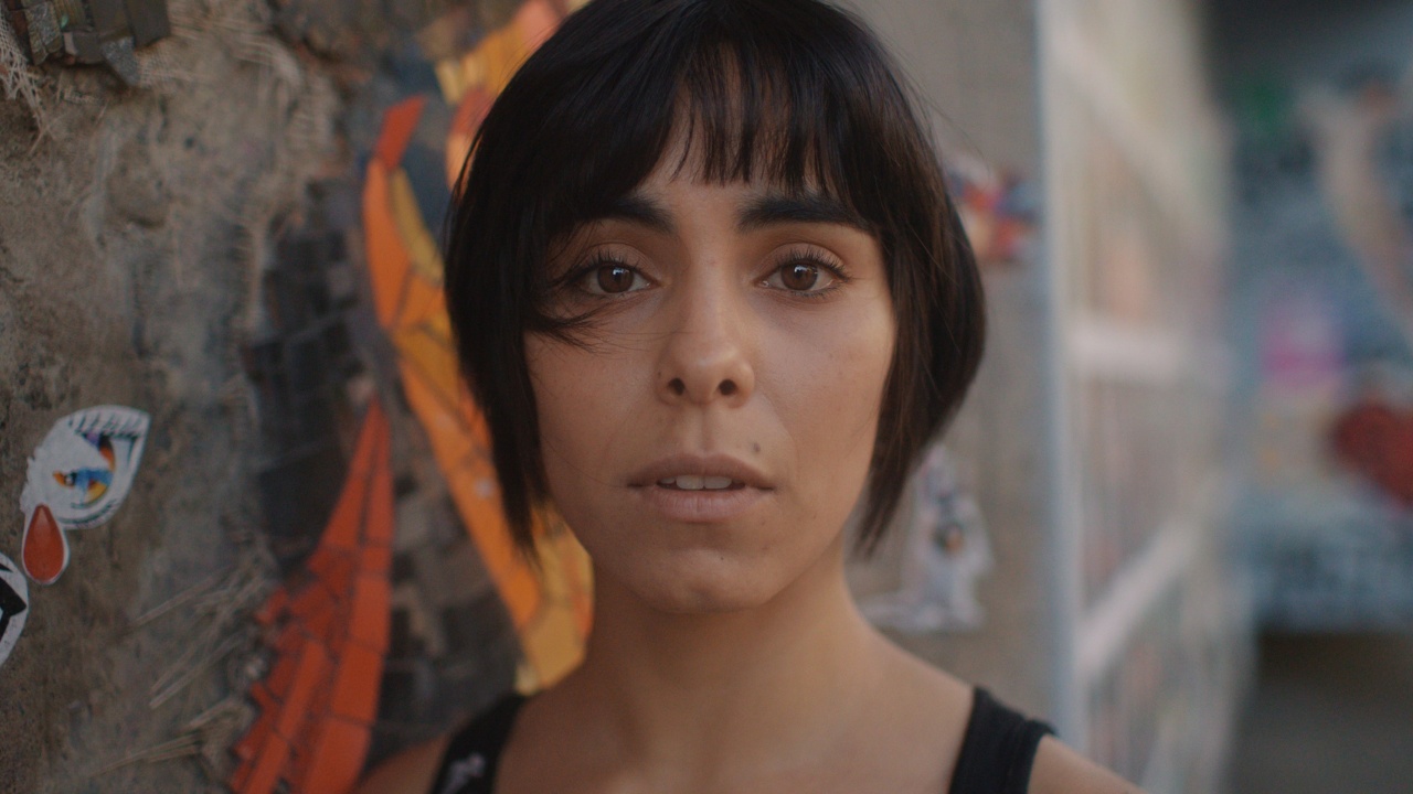 a woman with short hair stares directly into the camera