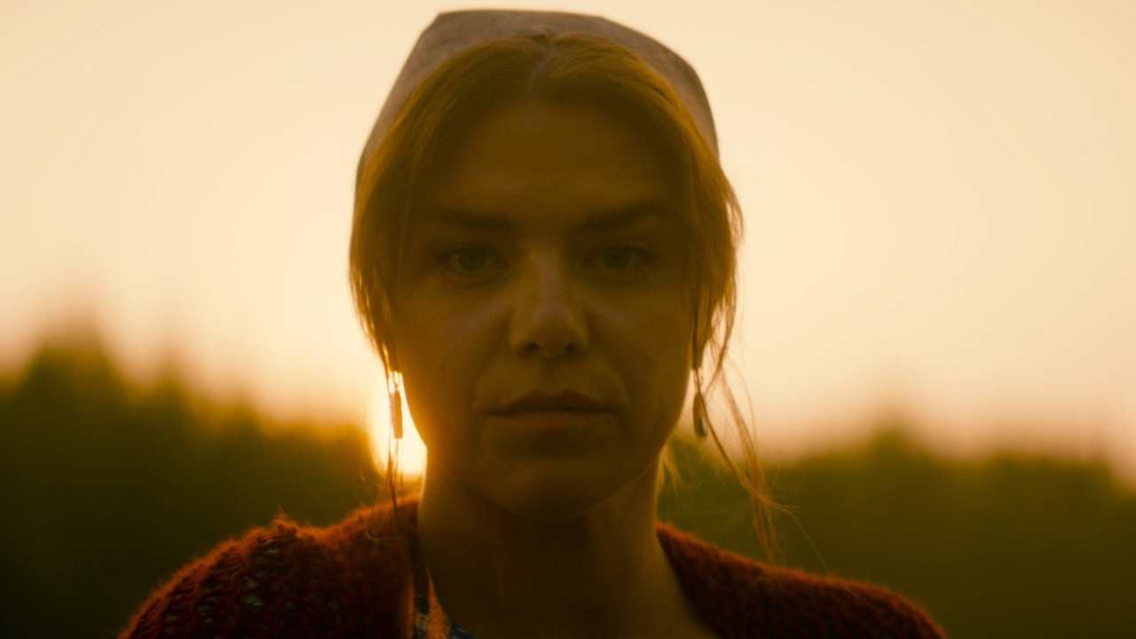 a woman in front of a sunset