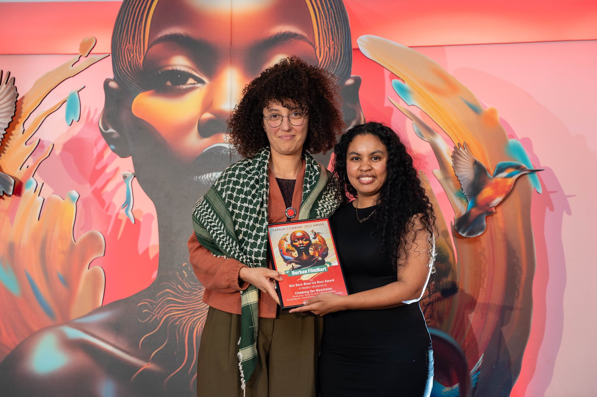 Two filmmakers holding an award